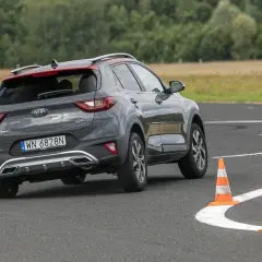 Szary Kia Stonic na torze z pachołkami, ćwiczący podsterowność.