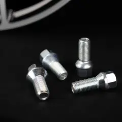 Cztery śruby do felg aluminiowych leżą na czarnym tle. Zastanawiasz się, jakie śruby do felg aluminiowych wybrać?