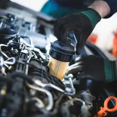 Mechanik wymienia filtr paliwa. Objawy jego zużycia mogą być różne, od spadku mocy po problemy z uruchomieniem silnika.