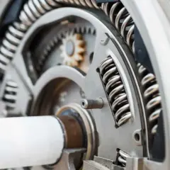 Mechanizm z zębatkami i sprężynami, element dociskowy w przekładni.