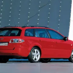 Czerwona Mazda 6 GG kombi stoi na tle nowoczesnego budynku.