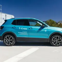 Błękitny Volkswagen T-Cross, idealny mały SUV dla żony, zaparkowany na dachu budynku.