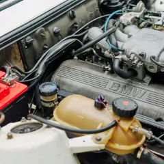 Silnik BMW, czerwony akumulator i zbiornik płynu chłodniczego. Ustalenie części po nr VIN to klucz do sprawnego działania.