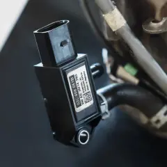 Czujnik ciśnienia spalin z etykietą VW AG. Kluczowy element układu wydechowego, zapewniający optymalną pracę silnika.