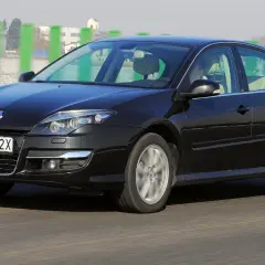 Czarna Laguna 3 2.0 dCi pędzi autostradą, mijając zielone słupki.