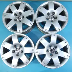 Cztery felgi aluminiowe VW Passat B5, widoczny rozstaw śrub 5x112. Stan dobry, widoczne ślady użytkowania.