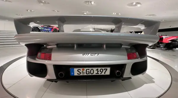 Srebrne Porsche 911 GT1 z masywnym spojlerem, gotowe do wyścigu.