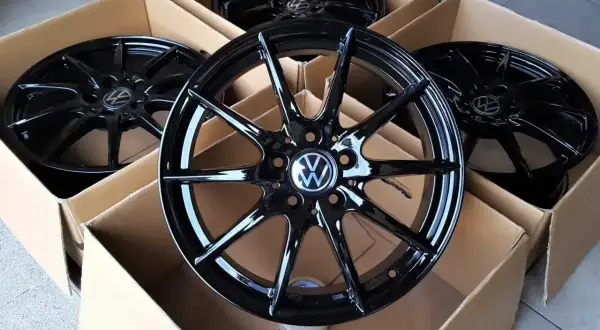 Cztery nowe, czarne felgi aluminiowe z logo VW, idealne do Golfa 4. Zastanawiasz się, jakie opony wybrać do swojego Golfa 4? Te felgi to świetny początek!