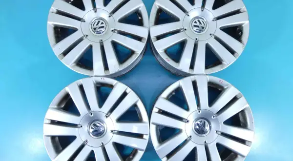Cztery felgi aluminiowe do Volkswagena Passata B6. Widoczny rozstaw śrub i logo producenta.