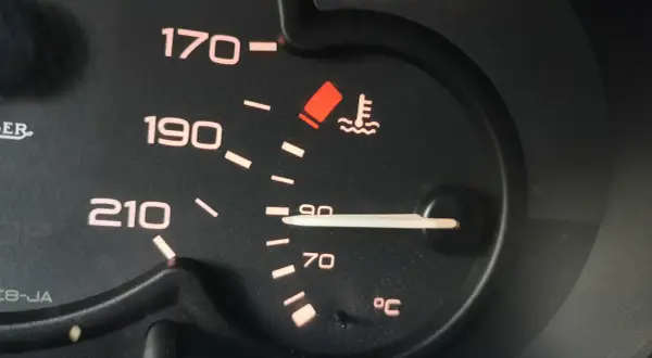 Wskaźnik pokazuje, że temperatura płynu chłodniczego jest w normie, blisko 90°C. Czerwona kontrolka ostrzega przed przegrzaniem.