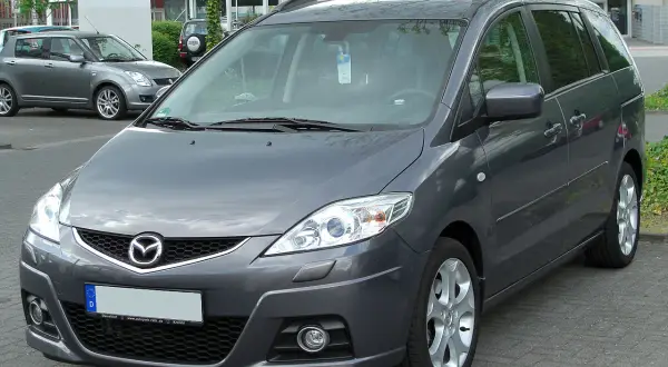 Szary Mazda 5 2.0 diesel zaparkowany na zewnątrz.
