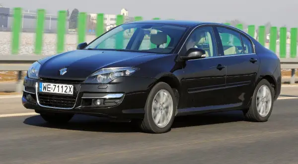 Czarna Laguna 3 2.0 dCi pędzi autostradą, mijając zielone słupki.