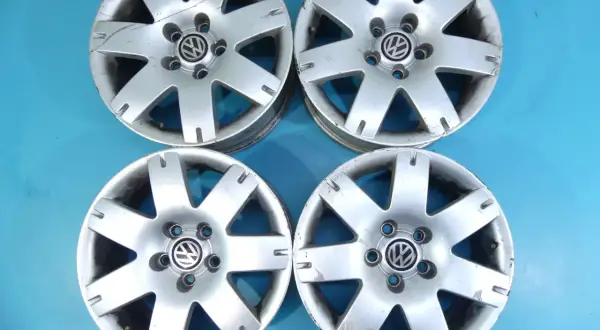 Cztery felgi aluminiowe VW Passat B5, widoczny rozstaw śrub 5x112. Stan dobry, widoczne ślady użytkowania.