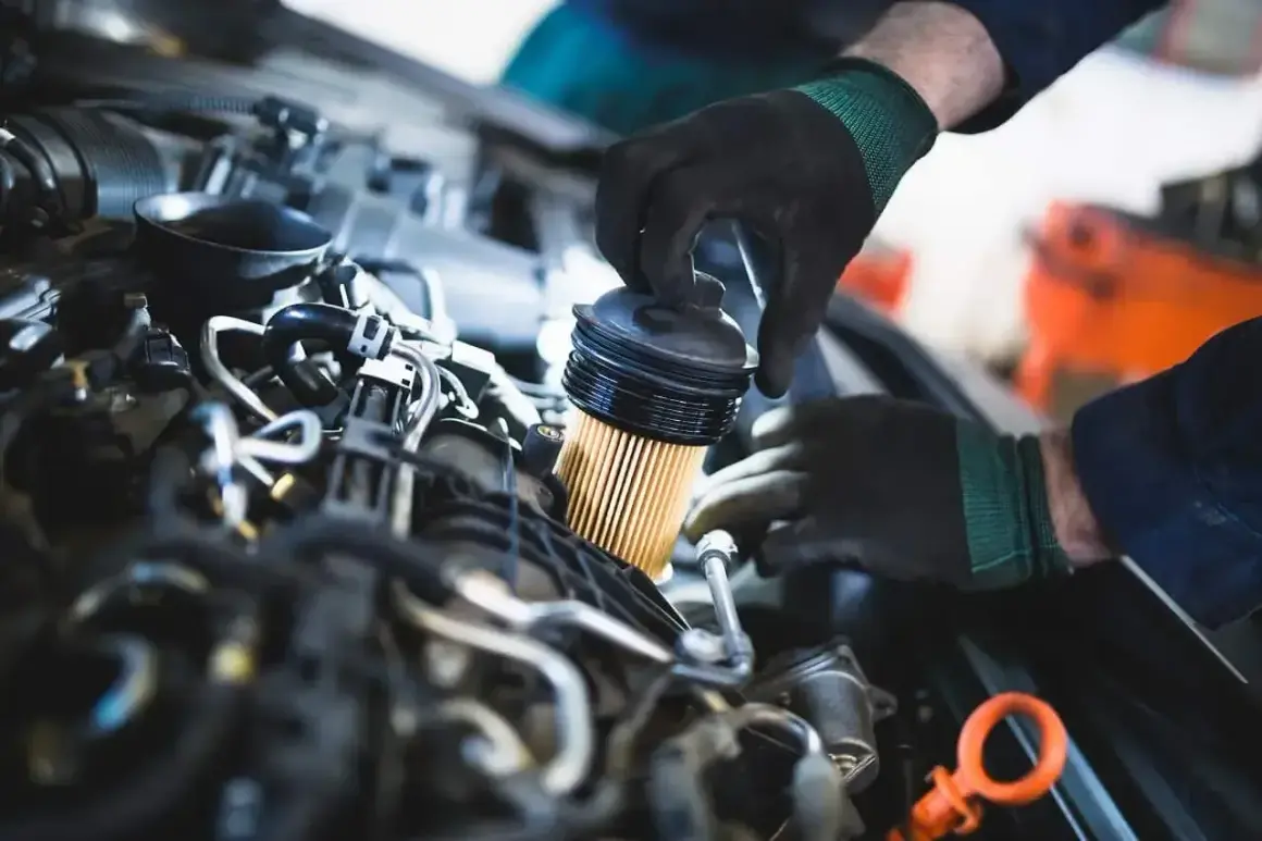 Mechanik wymienia filtr paliwa. Objawy jego zużycia mogą być różne, od spadku mocy po problemy z uruchomieniem silnika.
