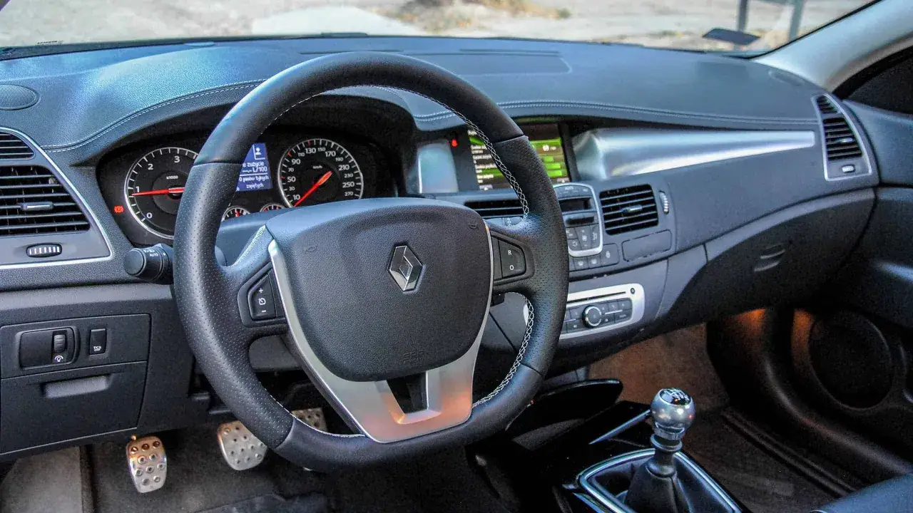 Wnętrze Renault Laguna 3 2.0 dCi: kierownica, deska rozdzielcza z zegarami i ekranem, dźwignia zmiany biegów.