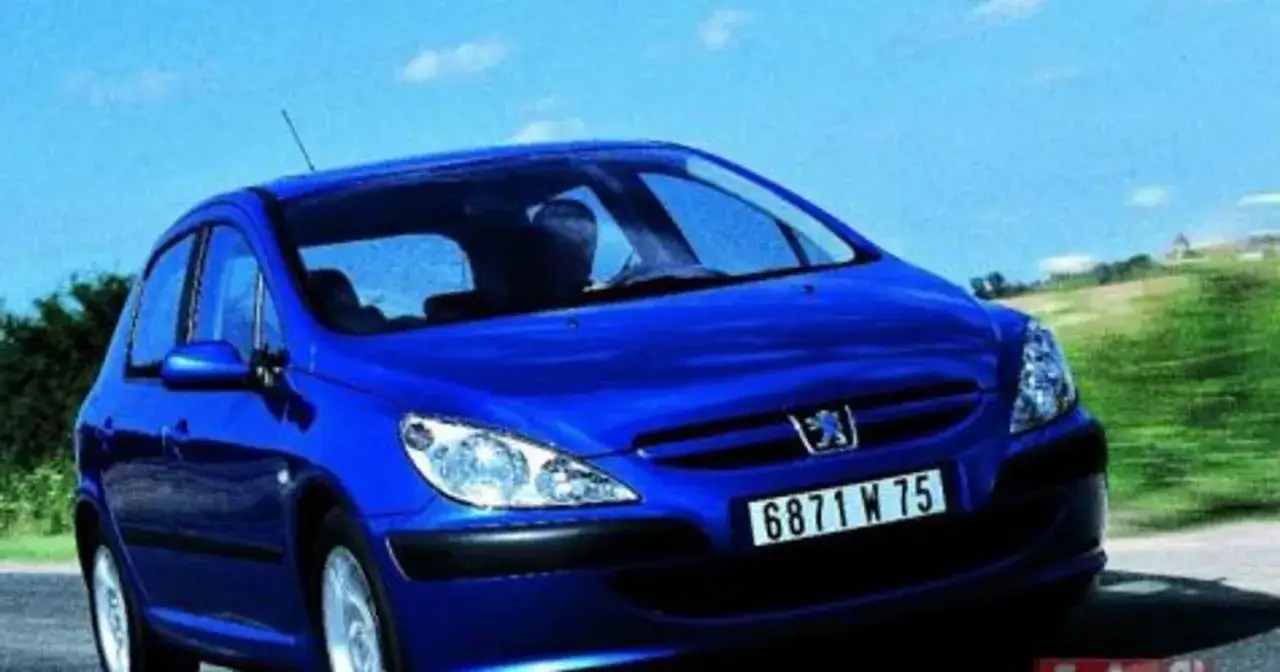 Błękitny Peugeot 307 2.0 HDI pędzi po drodze, za nim zielone wzgórza i błękitne niebo.