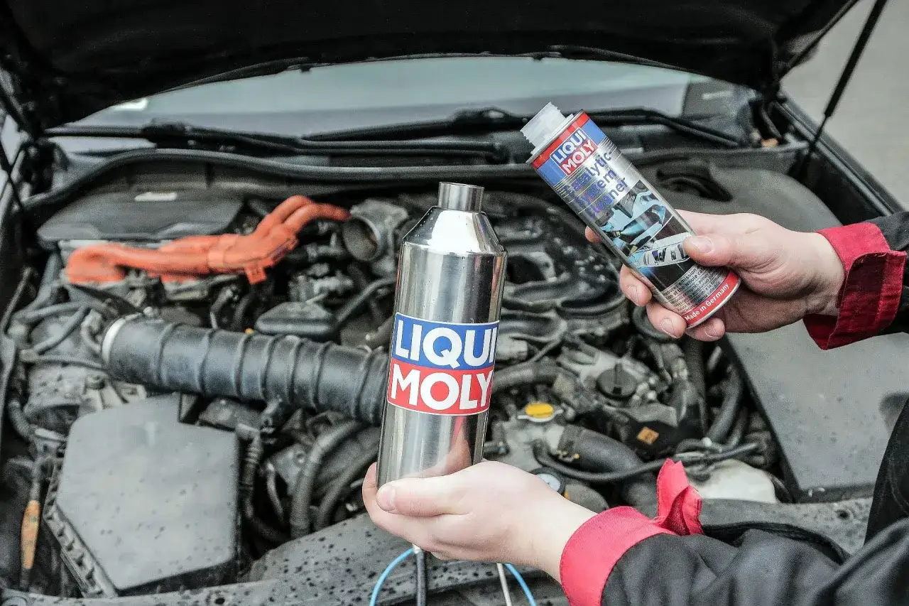 Ręce trzymające preparaty Liqui Moly do czyszczenia układu paliwowego. Zastanawiasz się, katalizator co to? To urządzenie w aucie, które wymaga dbałości.
