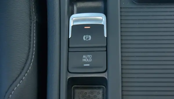 Przycisk "AUTO HOLD" w samochodzie. Pozwala na automatyczne utrzymanie pojazdu w miejscu po zatrzymaniu.