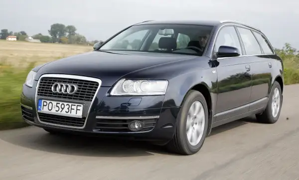 Ciemnogranatowe Audi A6 C6 2.7 TDI Avant w ruchu, z widocznym kierowcą i polskimi tablicami rejestracyjnymi.