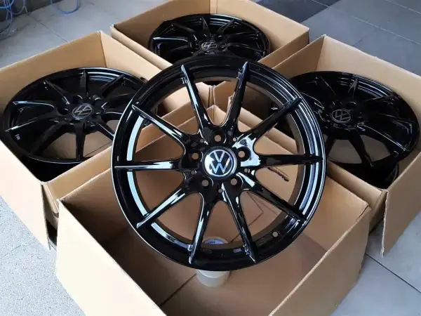 Cztery nowe, czarne felgi aluminiowe z logo VW, idealne do Golfa 4. Zastanawiasz się, jakie opony wybrać do swojego Golfa 4? Te felgi to świetny początek!