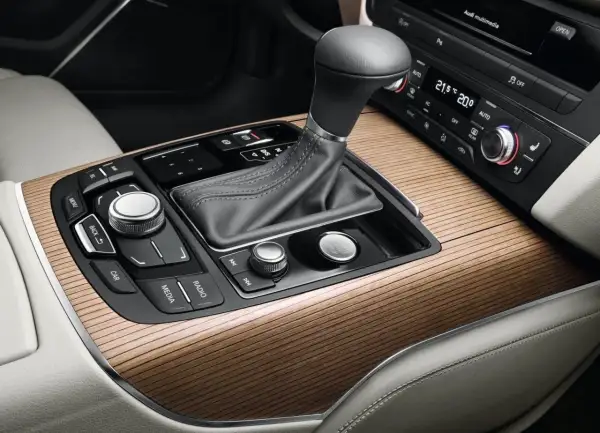 Eleganckie drewniane wykończenie konsoli środkowej Audi z dźwignią skrzyni biegów multitronic i przyciskiem Start/Stop.