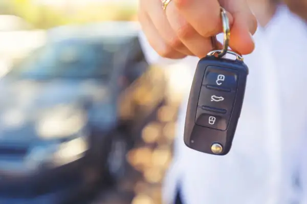 Dłoń trzyma kluczyk samochodowy. Czy to objawy uszkodzonego immobilizera? Auto nie odpala.