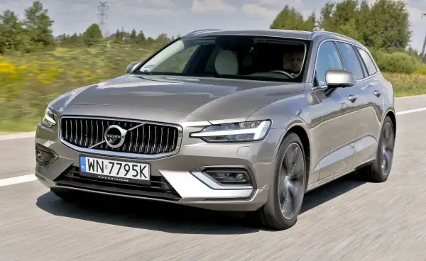 Szary Volvo V60 T5 w ruchu drogowym, z widocznym kierowcą.