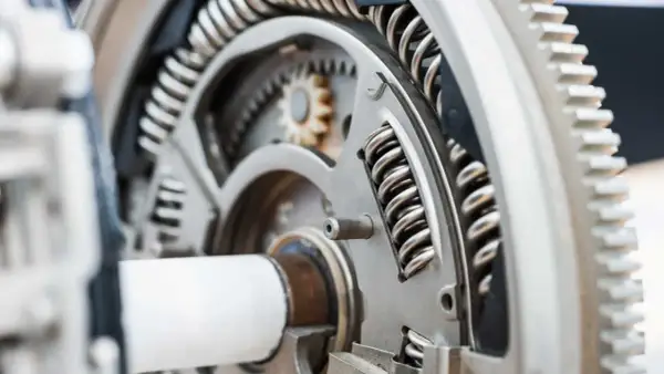 Mechanizm z zębatkami i sprężynami, element dociskowy w przekładni.