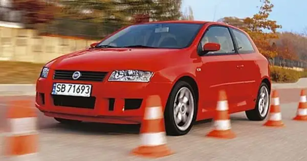 Czerwony Fiat Stilo 1.9 JTD manewruje między pachołkami na torze.