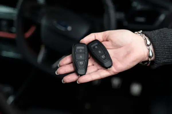 Dwie karty do kluczyka samochodowego w dłoni. Zastanawiasz się, keyless entry co to? To wygoda bez kluczyka.