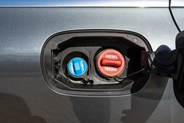 Dwa korki wlewu paliwa: czerwony z napisem DIESEL i niebieski z napisem AdBlue. Dowiedz się, adblue co to jest i do czego służy.