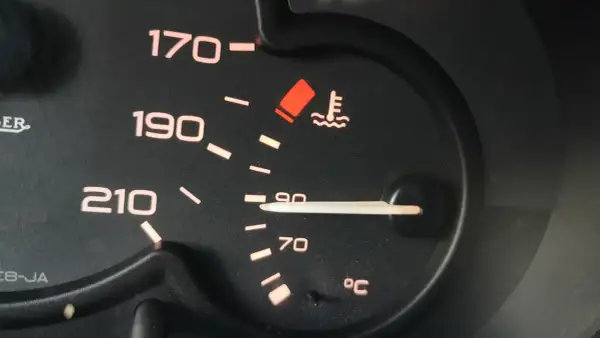 Wskaźnik pokazuje, że temperatura płynu chłodniczego jest w normie, blisko 90°C. Czerwona kontrolka ostrzega przed przegrzaniem.