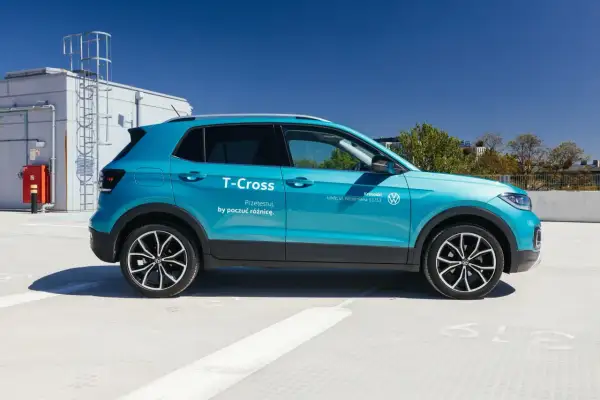 Błękitny Volkswagen T-Cross, idealny mały SUV dla żony, zaparkowany na dachu budynku.