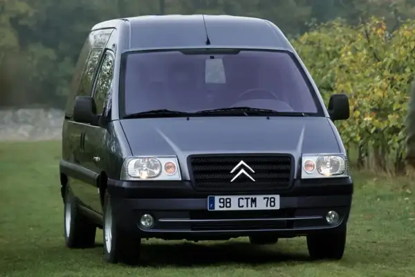 Szary Citroen Jumpy 2.0 HDI na trawie, gotowy do podróży.