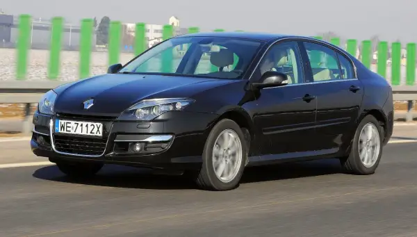 Czarna Laguna 3 2.0 dCi pędzi autostradą, mijając zielone słupki.