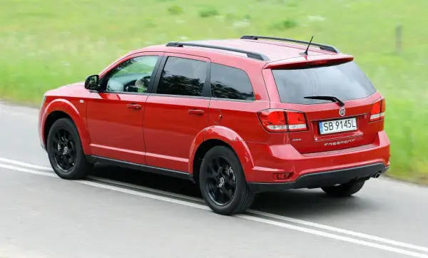 Czerwony Fiat Freemont na drodze. Wiele osób szuka fiat freemont opinie przed zakupem.